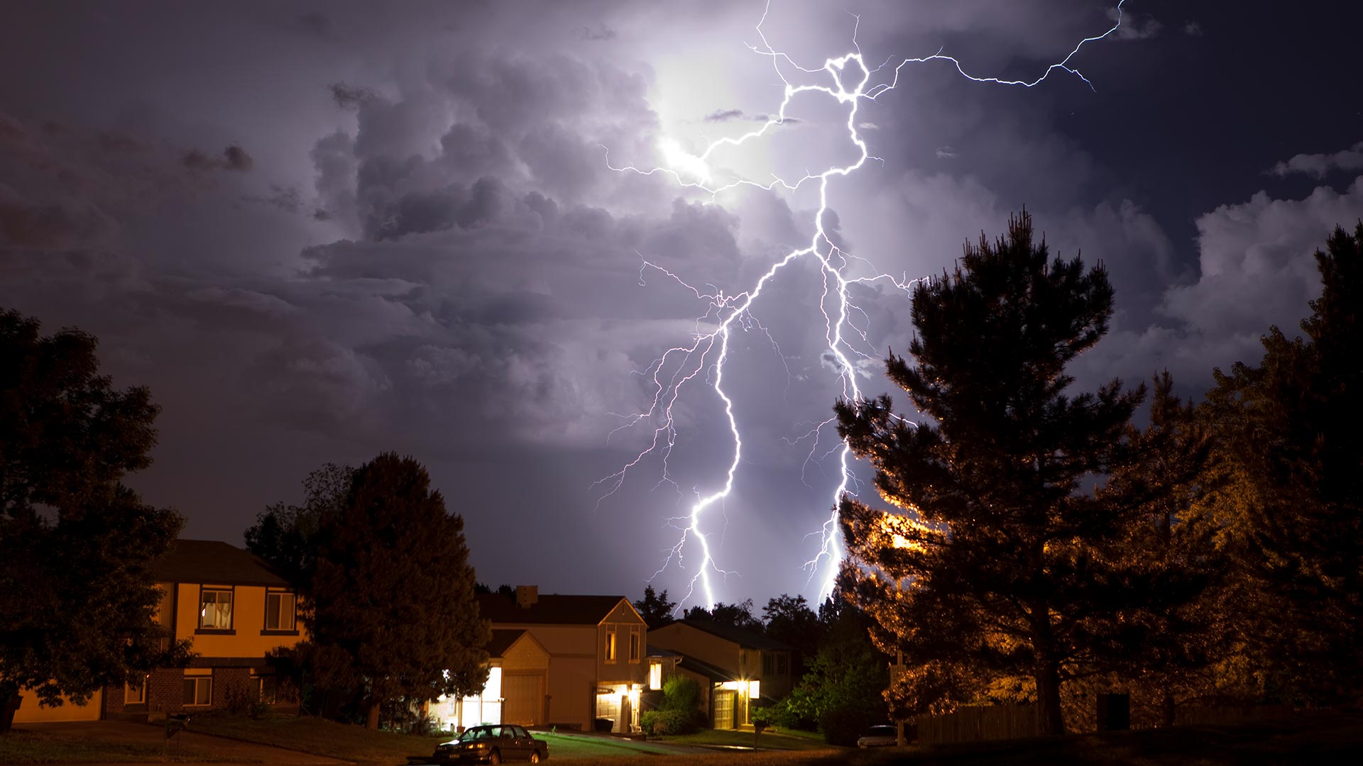 Lightning bolt and thunderhead storms over Denver neighborhood homes