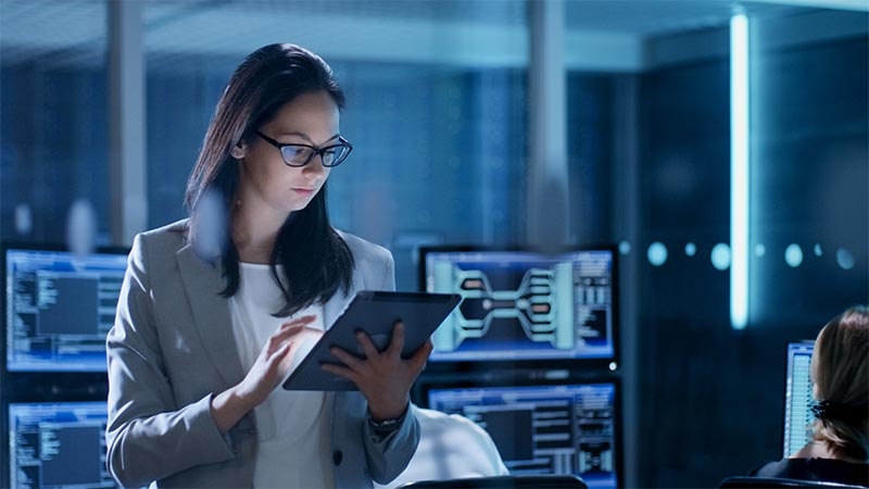 Female IT professional using her digital tablet at a data center