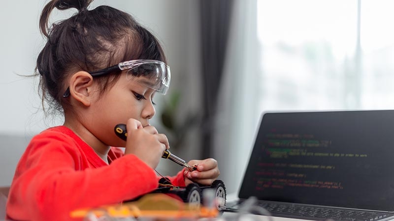 A little girl fixing her robo car