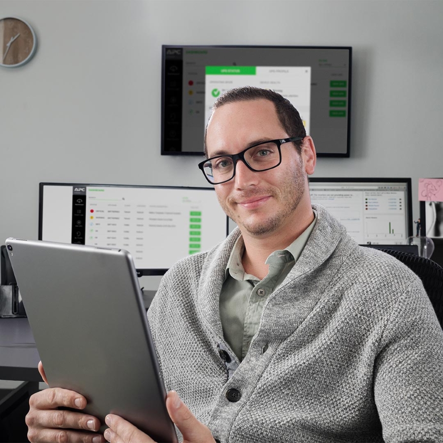 man smiling and holding tablet